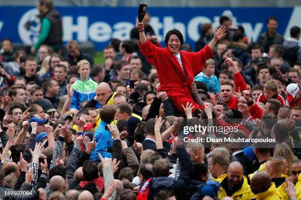 Yoshiaki Takagi of Utrecht celebrates with team mates as the fans cheer his name after winning the Eredivisie Europa League Play off match between FC...