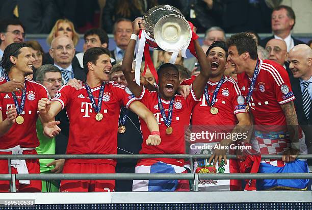 David Alaba of Bayern Muenchen lifts the trophy in celebration alongside team mates Daniel Van Buyten , Mario Gomez , Claudio Pizzaro and Mario...