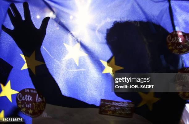 Man's shadow in a european flag is seen during the last meeting promoting the "no" vote on the 29 May EU constitution referendum, 27 May 2005 in...