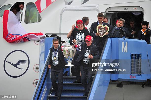 Captain Philipp Lahm and head coach Jupp Heynckes of Bayern Muenchen hold the trophy as Bastian Schweinsteiger and Thomas Mueller and the team...