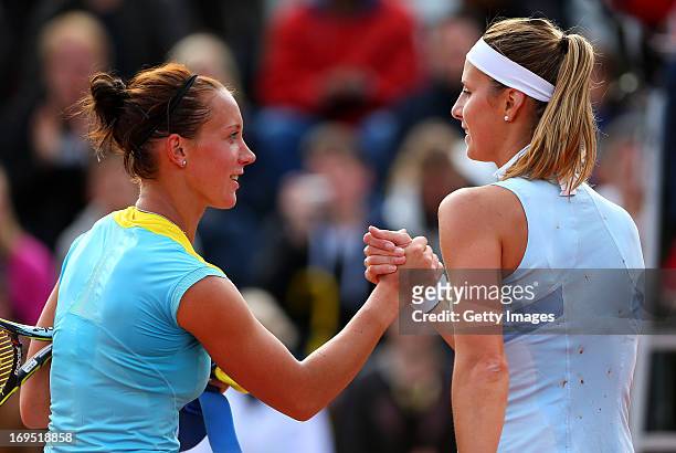 Dinah Pfizenmaier of Germany shakes hands at the net with her opponent Mandy Minella of Luxembourg after their women's singles match on day one of...