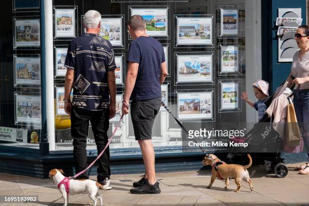 People looking at houses for sale in an estate agents window on 13th September 2023 in Cirencester, United Kingdom. Cirencester is known for having a...