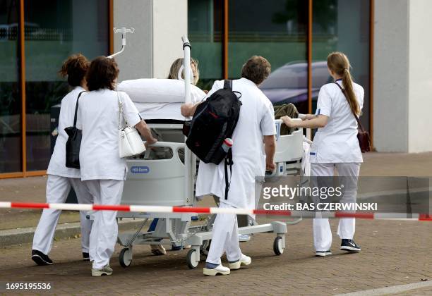 Medical staff push a patient on a hospital bed at the Erasmus University Medical Center in Rotterdam on September 28 which was cordoned off after two...