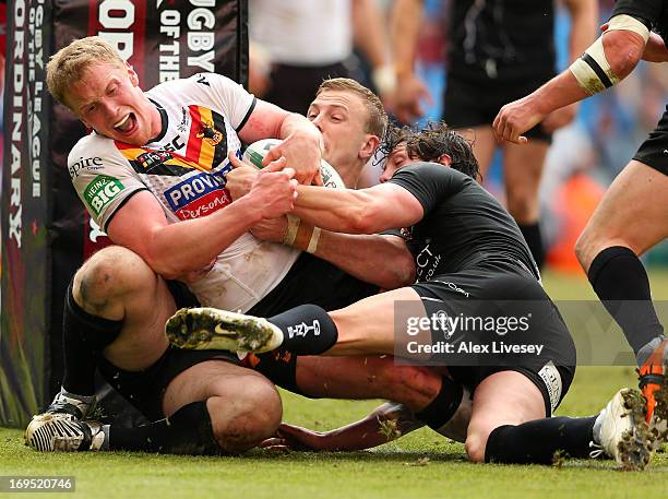 Tom Olbison of Bradford Bulls is tackled by Scott Grix of Huddersfield Giants during the Magic Weekend at Etihad Stadium on May 26, 2013 in...