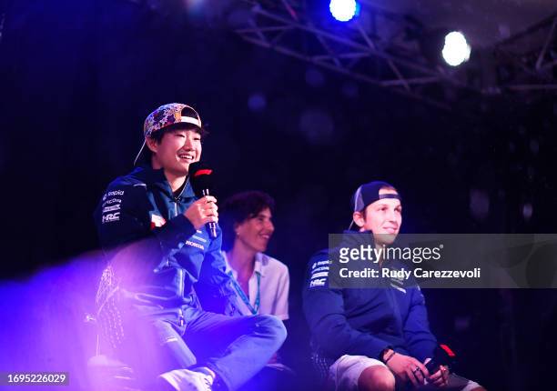 Yuki Tsunoda of Japan and Scuderia AlphaTauri and Liam Lawson of New Zealand and Scuderia AlphaTauri talk to the crowd on the fan stage after...