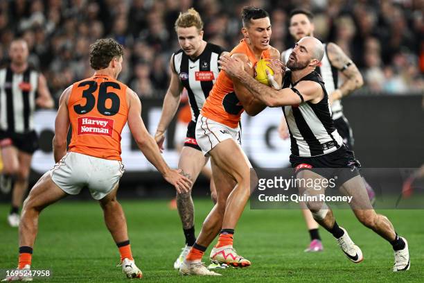 Isaac Cumming of the Giants is tackled by Steele Sidebottom of the Magpies during the AFL First Preliminary Final match between Collingwood Magpies...