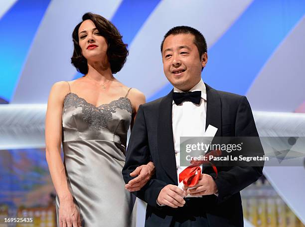 Actress Asia Argento stands next to Jia Zhangke of 'Tian Zhu Ding' as he receives the best screenplay award during the Closing Ceremony during the...