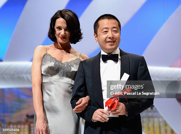 Actress Asia Argento stands next to Jia Zhangke of 'Tian Zhu Ding' as he receives the best screenplay award during the Closing Ceremony during the...