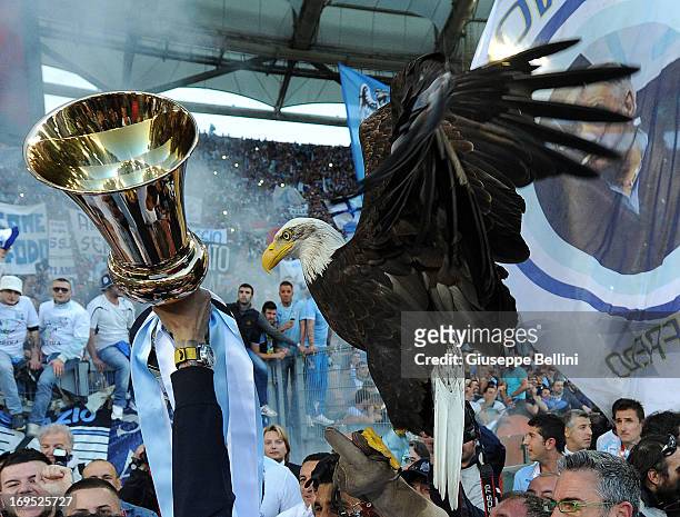 Lazio mascot Olimpia, a female American golden eagle, is held with Tim Cup after the TIM cup final match between AS Roma v SS Lazio at Stadio...