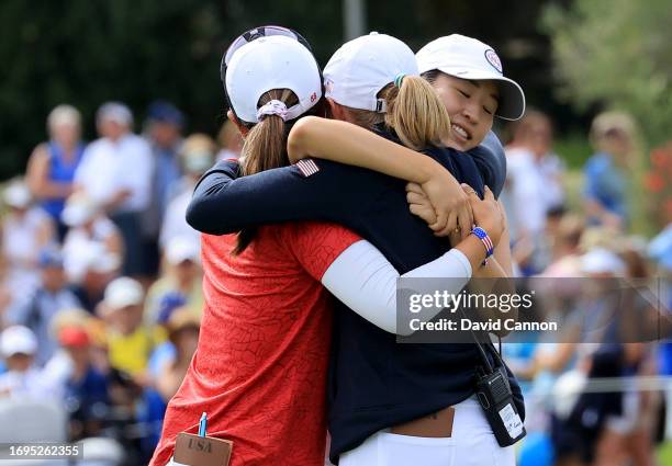 Danielle Kang and Andrea Lee of The United States are congratulated by USA team captain Stacy Lewis after their win on the 18th hole in their match...