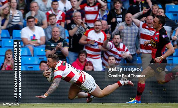 Josh Charnley of Wigan dives into score a try past Kevin Sinfield of Leeds during the Super League Magic Weekend match between Leeds Rhinos and Wigan...