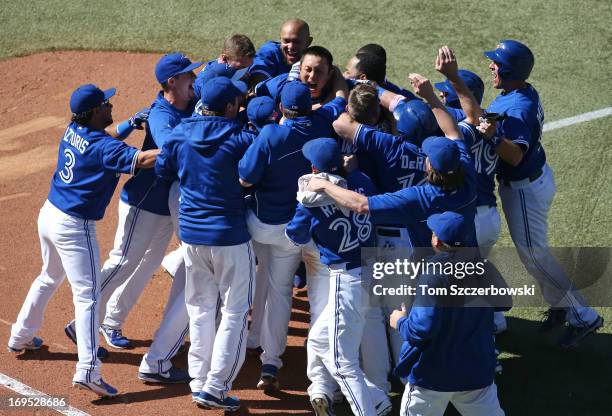 Munenori Kawasaki of the Toronto Blue Jays celebrates with teammates after driving in the winning runs in the ninth inning during MLB game action...