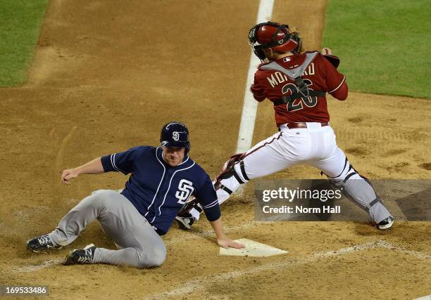 Jedd Gyorko of the San Diego Padres slides safely into home as Miguel Montero of the Arizona Diamondbacks attempts to block the plate at Chase Field...