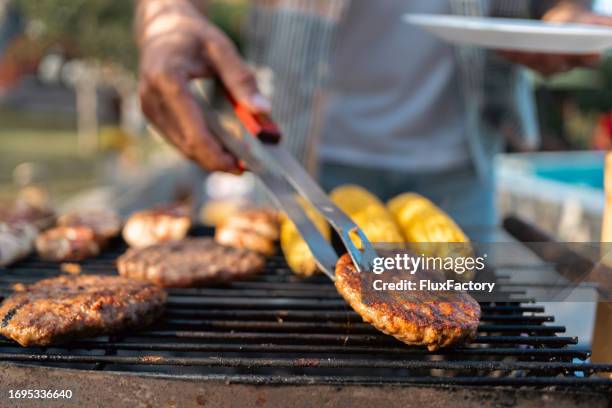 unrecognizable caucasian man making barbecue - grill fire meat stockfoto's en -beelden