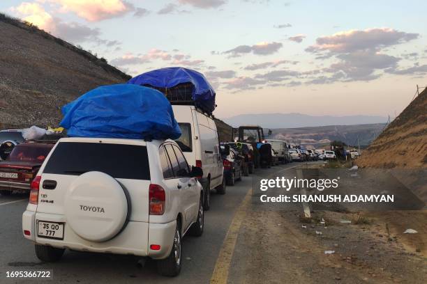 Armenians fleeing Nagorno-Karabakh sit in a long traffic jam of vehicles along the Lachin corridor on September 28, 2023. Azerbaijan on September 28,...