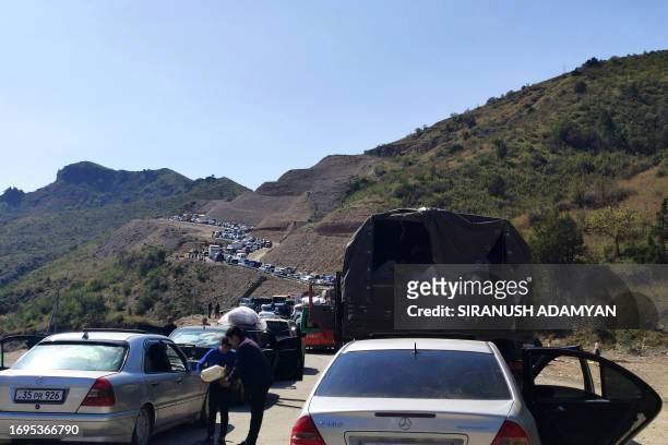 Armenians fleeing Nagorno-Karabakh sit in a long traffic jam of vehicles along the Lachin corridor on September 28, 2023. Azerbaijan on September 28,...