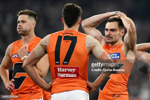Harry Himmelberg, Finn Callaghan and Stephen Coniglio of the Giants look dejected after defeat during the AFL First Preliminary Final match between...
