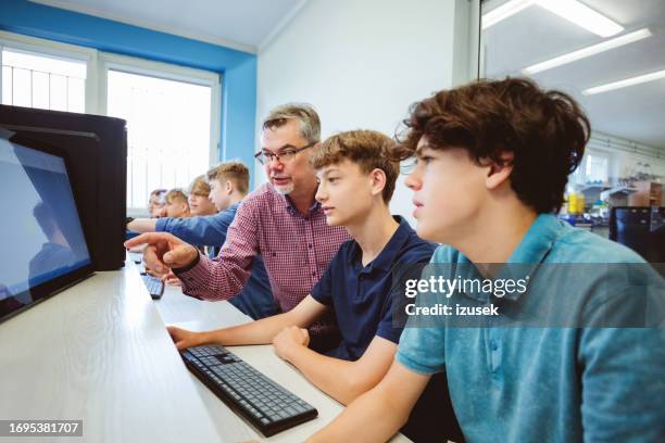 des lycéens discutent avec un professeur pendant les cours de programmation - computer lab high school with computer screen photos et images de collection