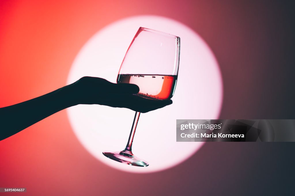 Woman holding wine glass, close-up.