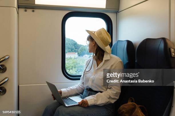 young woman working on laptop while traveling on train. copy space - working on laptop in train top view imagens e fotografias de stock