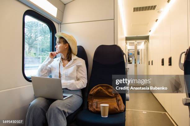 young woman working on laptop while traveling on train. copy space - working on laptop in train top view imagens e fotografias de stock