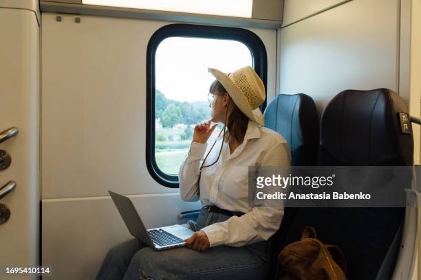 young woman working on laptop while traveling on train. copy space - working on laptop in train top view imagens e fotografias de stock