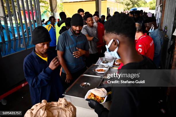 Migrants are given food after arriving from the Lampedusa landing seen outside the Red Cross Refugee Center on September 22, 2023 in Turin, Italy....