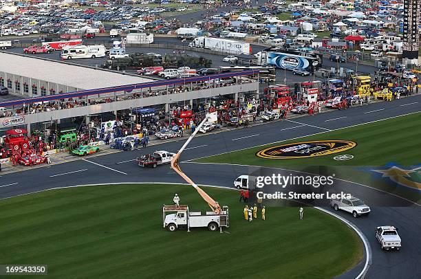 Track workers take down an aerial Fox Sports camera in the infield from a cherry picker during a red flag in the NASCAR Sprint Cup Series Coca-Cola...