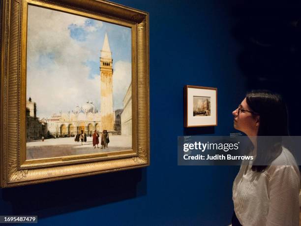 Woman views 'Venice: the Piazza San Marco' by Richard Parkes Bonington at an exhibition of watercolour paintings by Bonington and J.M.W. Turner at...