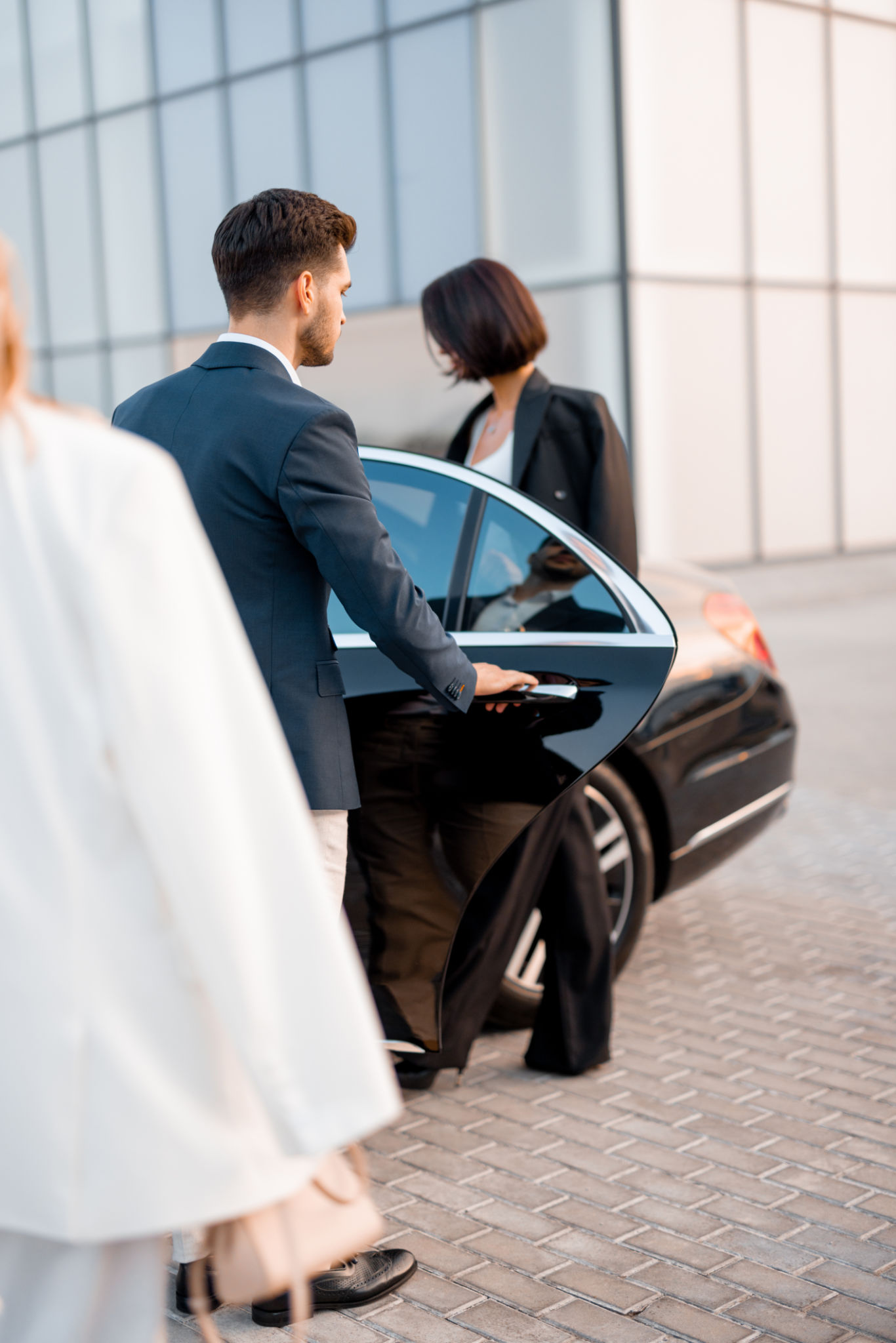 Business couple on parking lot near luxury car Business couple on parking lot near luxury car