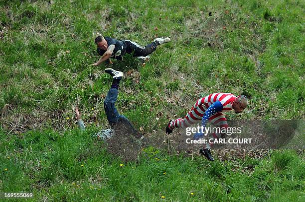 Competitors run and tumble down Coopers Hill in pursuit of a fake foam round Double Gloucester cheese during the annual cheese rolling and wake near...