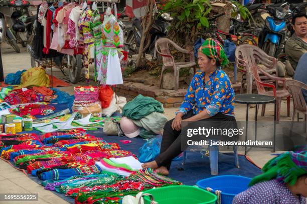 one woman (ethnic minority; north vietnam mountain tribes) is selling textiles on the market in bao lac, north vietnam - bao lac stock pictures, royalty-free photos & images