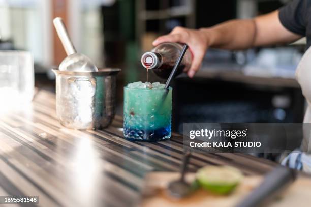 waiter preparing a blue lagoon cocktail in a bar - blue curacao stock pictures, royalty-free photos & images