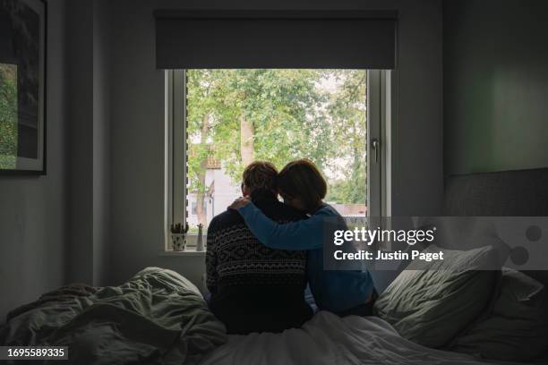 powerful rear view image of a mature woman offering emotional support to her partner - couple alone embracing stock pictures, royalty-free photos & images