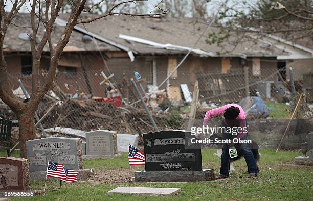 Pat Newcomb cleans debris from around the headstone of her late husband in the Moore City Cemetery on Memorial Day May 27, 2013 in Moore, Oklahoma....