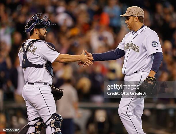 Starting pitcher Aaron Harang of the Seattle Mariners is congratulated by catcher Kelly Shoppach after defeating the San Diego Padres 9-0 at Safeco...
