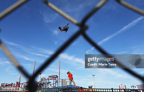 Worker watches as a man rides the 'Boardwalk Flight' ride at Luna Park at Coney Island on May 27, 2013 in the Brooklyn borough New York City. This...