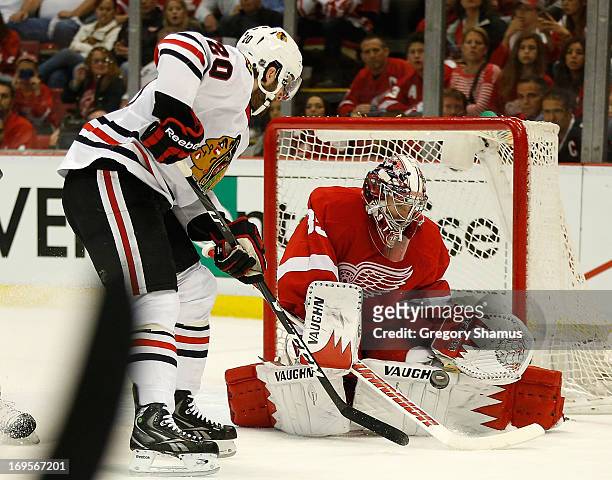 Jimmy Howard of the Detroit Red Wings makes a first period save next to Brandon Saad of the Chicago Blackhawks in Game Six of the Western Conference...
