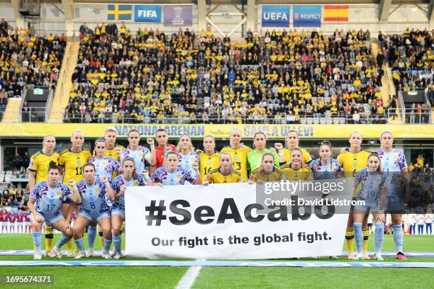 Players of Sweden and Spain hold a banner which reads 'SeAcabo, Our fight is the global fight.' in support of the Spain national women's team prior...