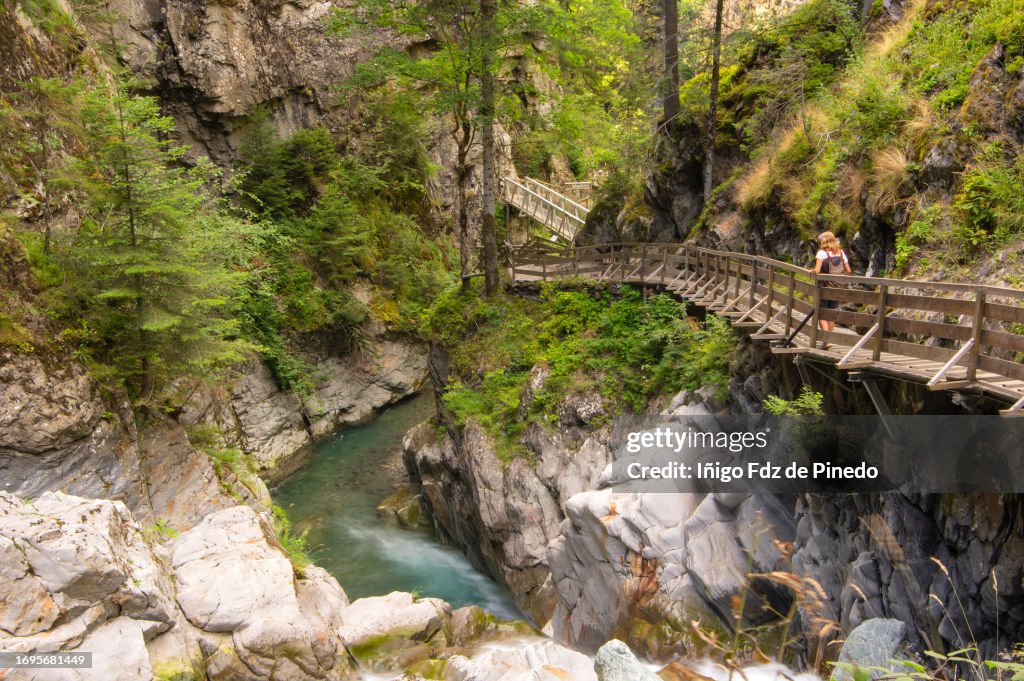 A woman walking along Diosaz's Gorges suspended path, Servoz, Haute-Saboie, Auvergne-Rhône-Alpes, France.
