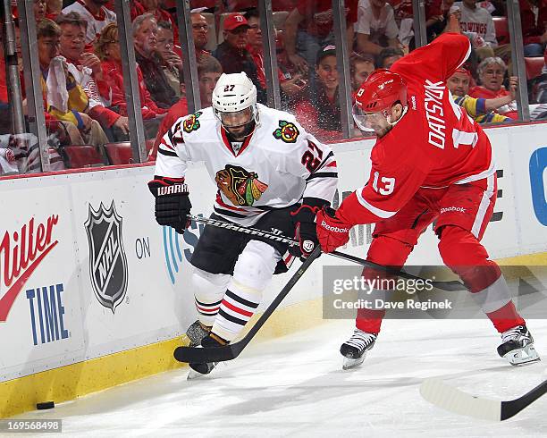 Johnny Oduya of the Chicago Blackhawks and Pavel Datsyuk of the Detroit Red Wings battle for the puck behind the net during Game Six of the Western...