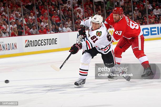 Marian Hossa of the Chicago Blackhawks shoots the puck as Johan Franzen of the Detroit Red Wings puts a stick on him during Game Six of the Western...
