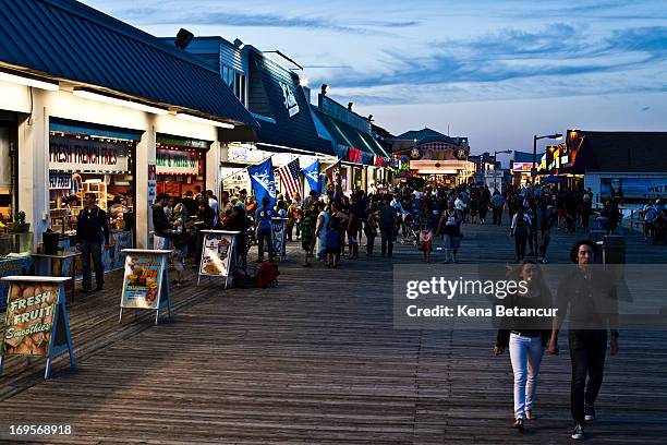 People walk along the boardwalk at Point Pleasant Beach on the first weekend of New Jersey beaches re-opening to the public on May 27, 2013 in Point...