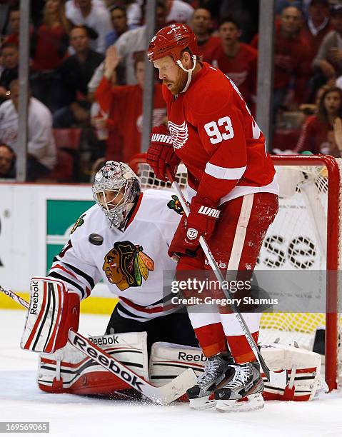 Corey Crawford of the Chicago Blackhawks makes a second period save next to Johan Franzen of the Detroit Red Wings in Game Six of the Western...