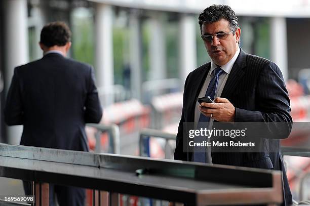 Andrew Demetriou looks at his phone after a press conference at Metricon Stadium on May 28, 2013 on the Gold Coast, Australia.