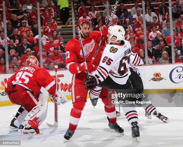 Kyle Quincy of the Detroit Red Wings and Andrew Shaw of the Chicago Blackhawks battle in front of the net during Game Six of the Western Conference...