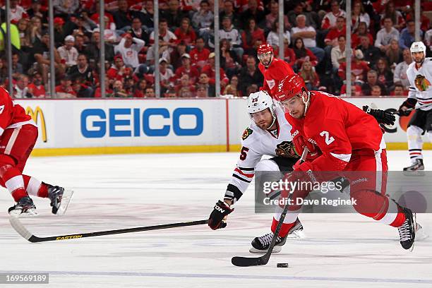 Brendan Smith of the Detroit Red Wings skates with the puck as Viktor Stalberg of the Chicago Blackhawks gives chase during Game Six of the Western...