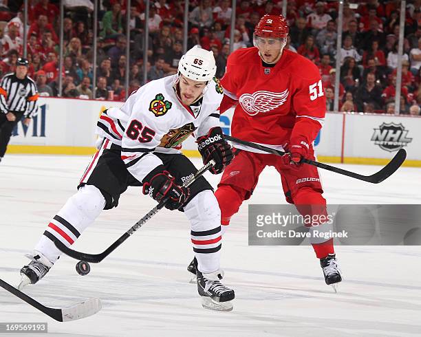 Andrew Shaw of the Chicago Blackhawks settles down the puck as Valtteri Filppula of the Detroit Red Wings skates behind him during Game Six of the...