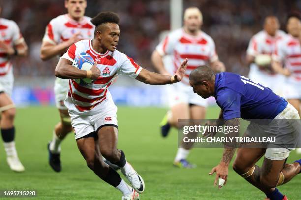 Japan's right wing Kotaro Matsushima hands off a tackle from Samoa's right wing Ed Fidow as he runs with the ball during the France 2023 Rugby World...