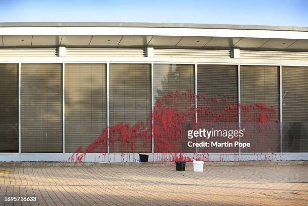 Broom and buckets sit by the red paint sprayed on the front of the Teledyne e2v building on September 28, 2023 in Chelmsford. A single activist...